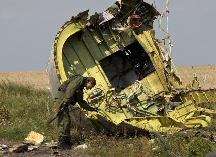A pro-Russian rebel examines wreckage of Malaysia Airlines Flight 17.