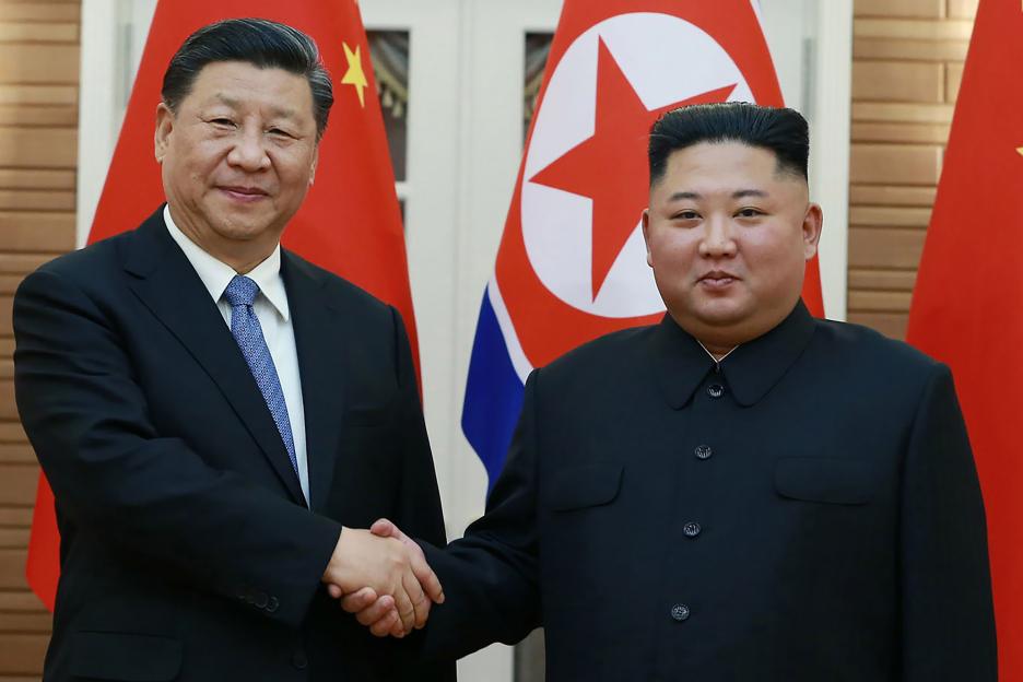 Xi Jinping and Kim Jong Un shaking hands.