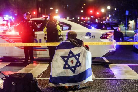 Person draped in Israeli flag at a crime scene.