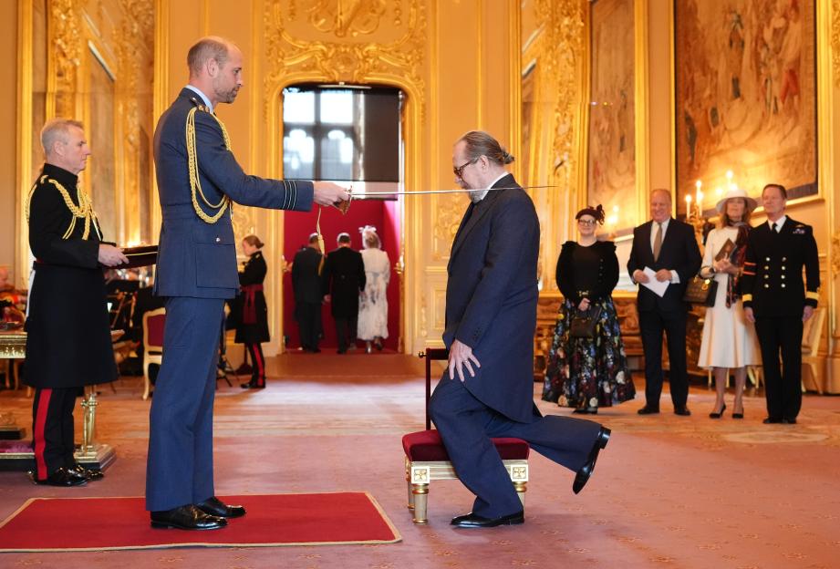 Sir Gary Oldman being knighted by the Prince of Wales at Windsor Castle.