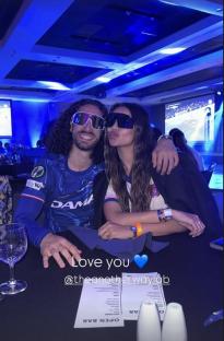 Couple wearing sunglasses at a table.
