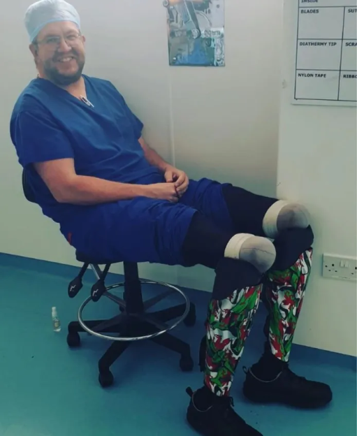 Smiling surgeon sitting in a chair wearing patterned leg braces.