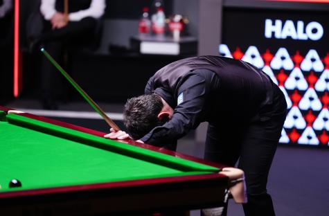Ronnie O'Sullivan leaning over a snooker table after missing a shot.