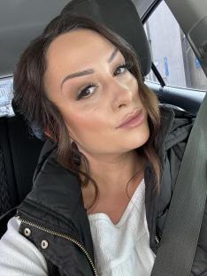 Close-up selfie of a woman in a car.