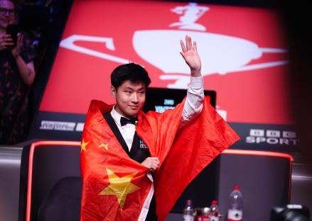 Zhao Xintong holding a trophy and a Chinese flag.
