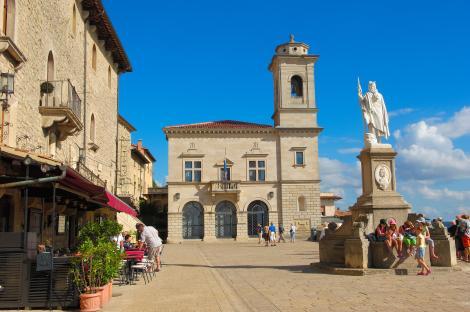 Piazza della Liberta in San Marino, with a statue and buildings.