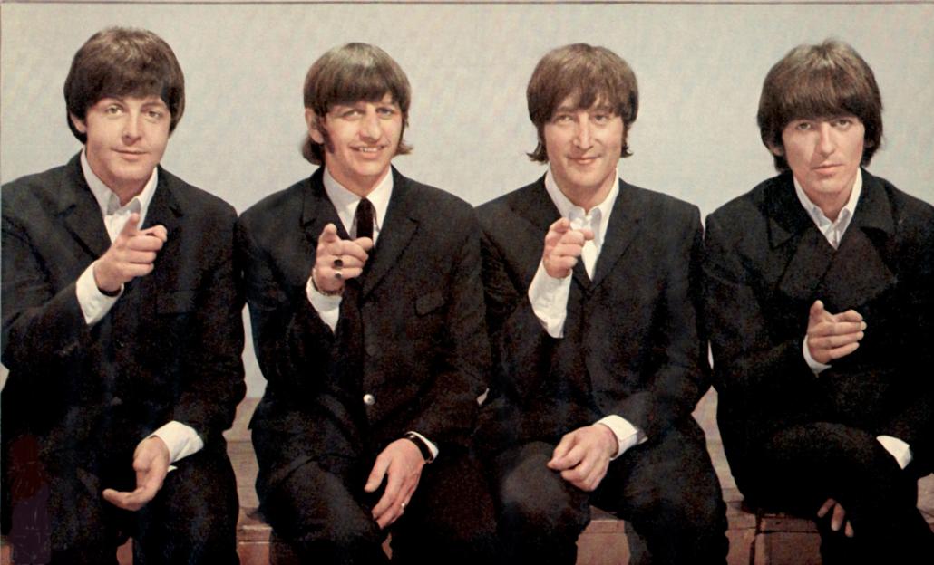 The Beatles pointing at the camera.