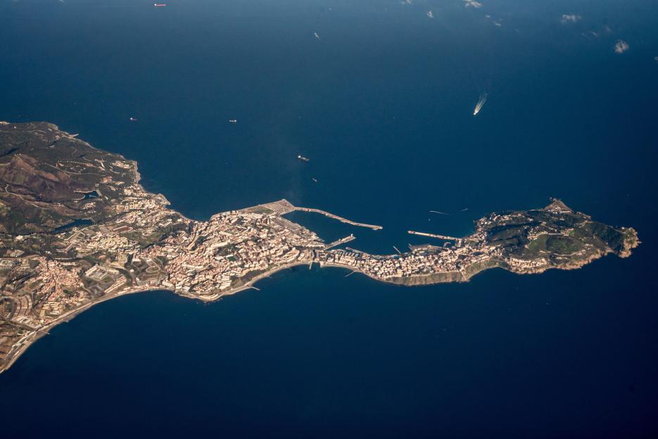 Aerial view of Ceuta, Spain, a city along the coastline with a port extending into the Mediterranean Sea.
