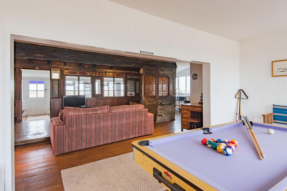Interior view of a Victorian train carriage converted into a living space with a pool table.