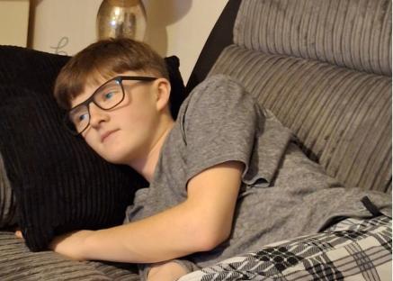 Photo of Thomas, one of three missing children, wearing a grey shirt and glasses.
