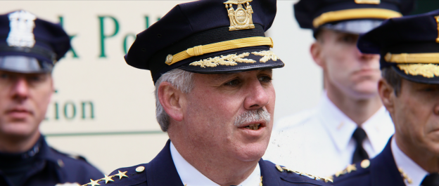James Burke, in police uniform, speaking.