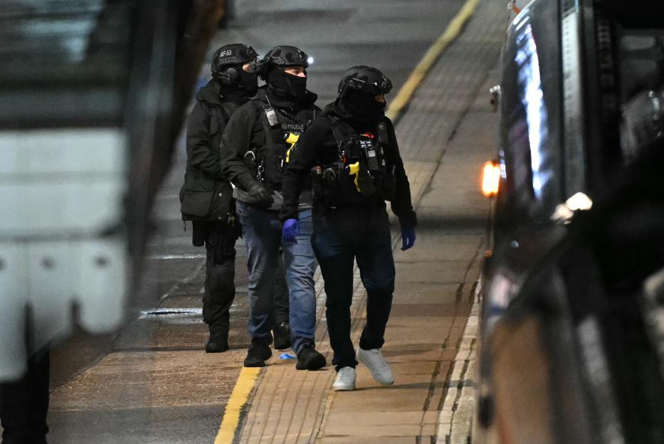 Police officers walk along a train station platform in Huntingdon, UK, following a stabbing on a train.