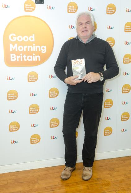 Tommy Rhattigan holding his book "1963: A Slice of Bread and Jam" in front of a "Good Morning Britain" backdrop.