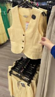 Pale yellow linen vest and shorts set on display.
