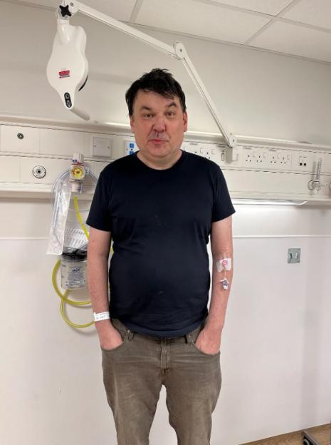 Man in hospital room with IV.