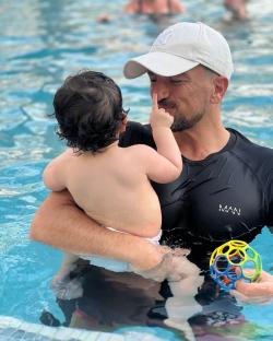 A father and baby in a swimming pool.