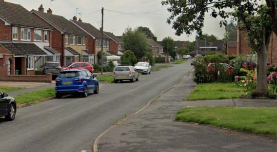 Residential street with parked cars.