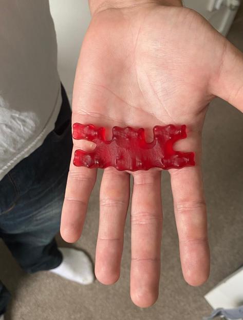 Six red Haribo gummy bears stuck together.