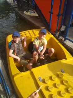 Two boys in a yellow Lego-themed boat.