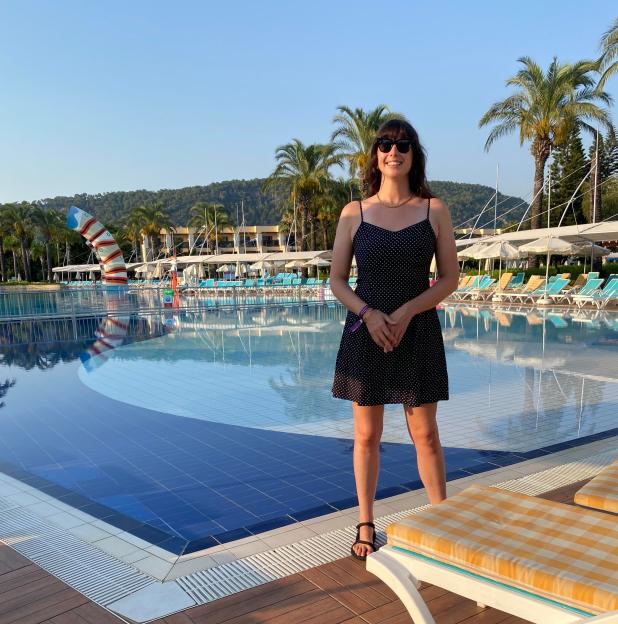 Woman in polka dot dress by a resort pool.