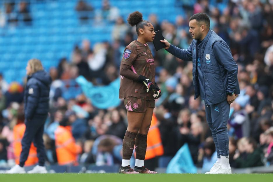 Manchester City goalkeeper Khiara Keating receives instructions from her coach.