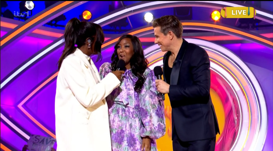 Two women and a man on a game show.
