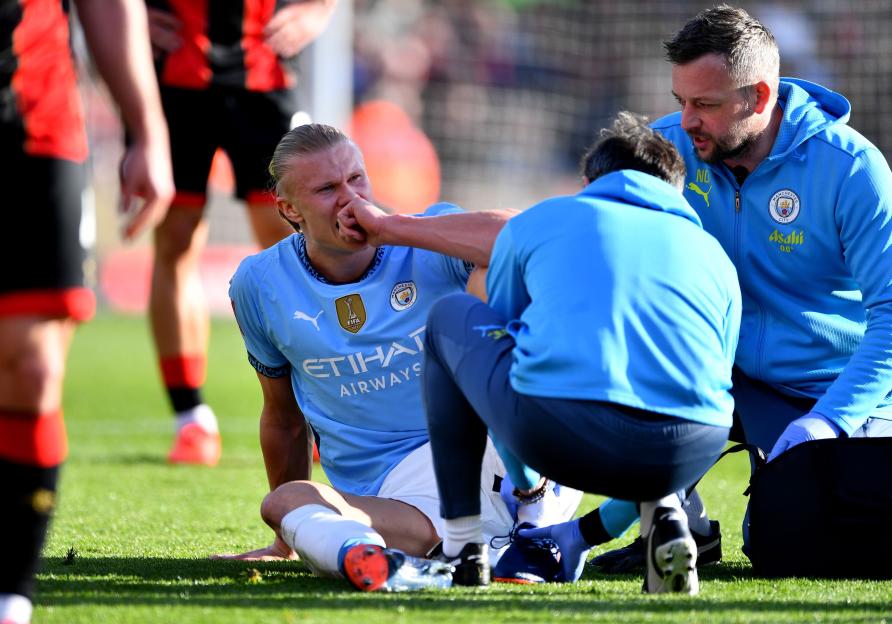 Erling Haaland of Manchester City receiving medical attention on the field.