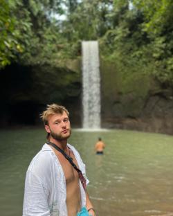 Man standing near waterfall.
