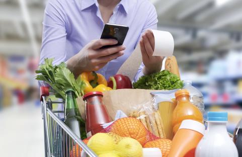 Woman checking grocery receipt on her phone.