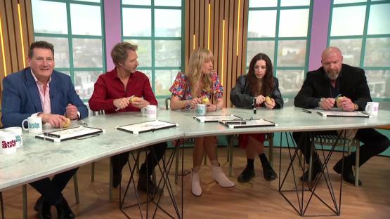 Five people sitting at a table peeling potatoes.