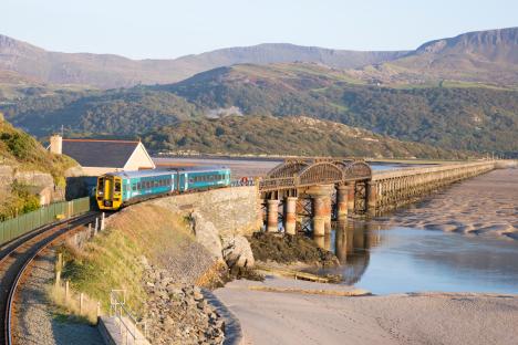 Train crossing Barmouth railway viaduct over the Mawddach estuary.