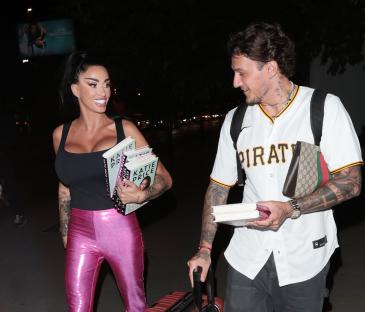 Katie Price and JJ Slater carrying books and luggage.