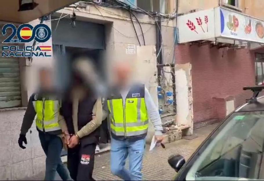 A handcuffed person being escorted by two police officers.