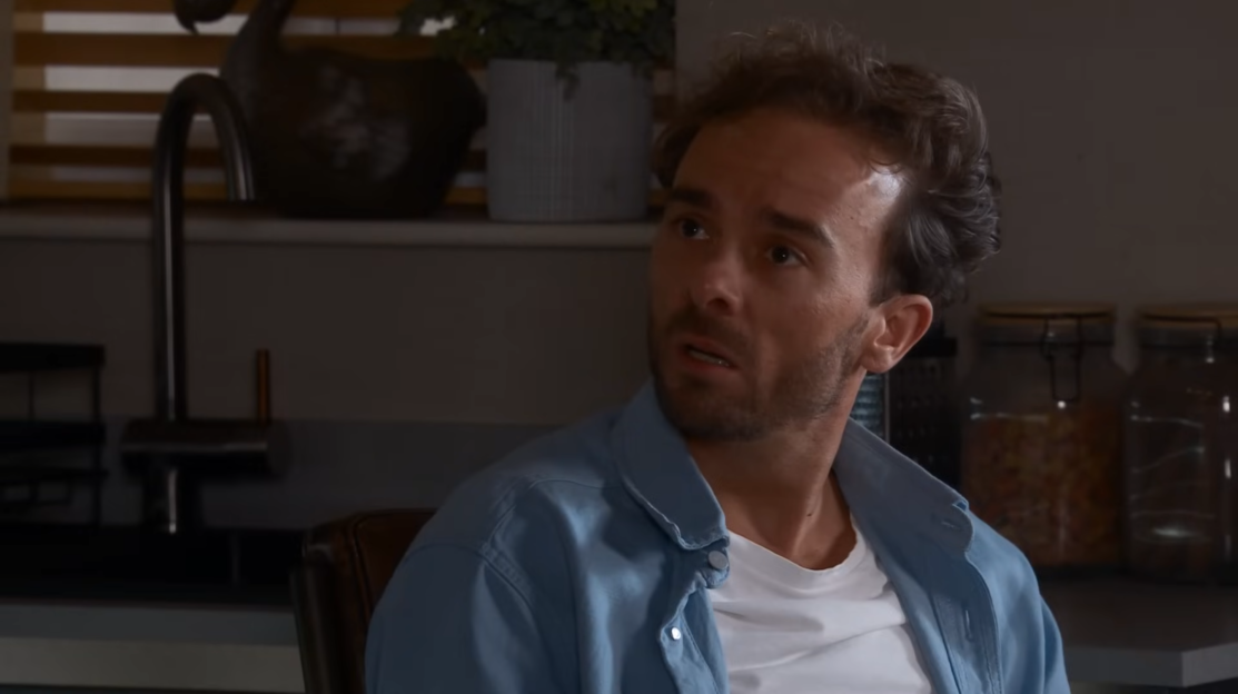 Screenshot of a man looking pensive.