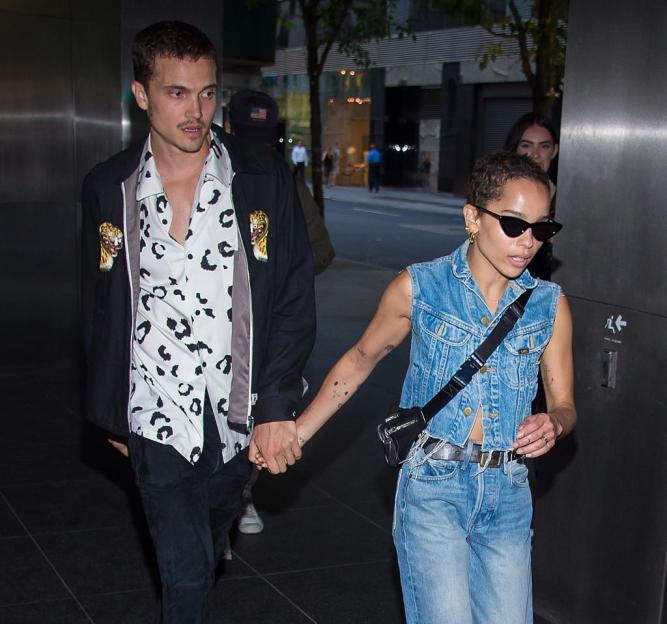 Karl Glusman and Zoe Kravitz holding hands.