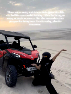 Woman posing next to a red ATV in a desert.