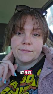 Close-up selfie of a woman with bangs and light blue nail polish.