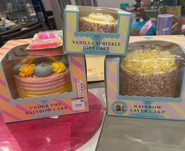 Three M&S birthday cakes: vanilla sprinkle, rainbow layer, and under the rainbow.