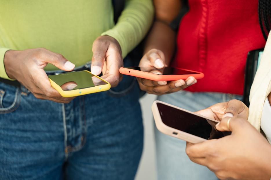 Close up of three women using smartphones.