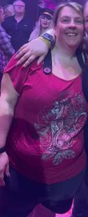 Woman in a maroon shirt with a stylized cat design.