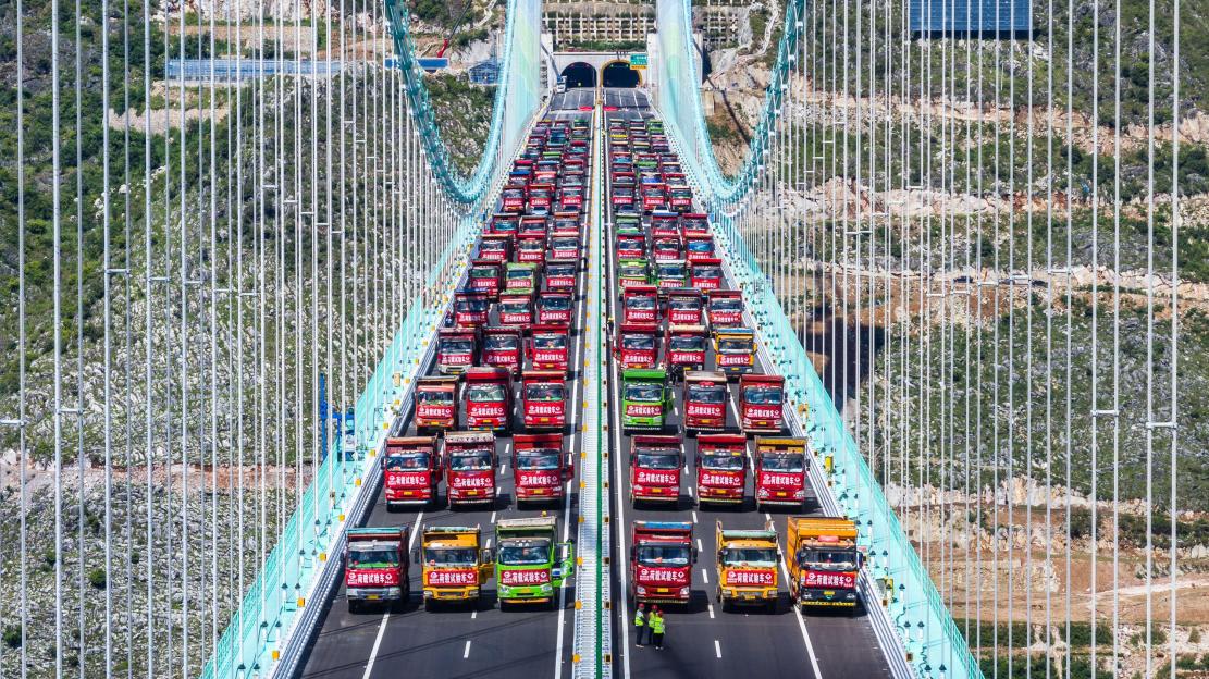 World’s tallest bridge put to the ULTIMATE test as fleet of 96 trucks loaded with 3,360 tons of cargo park on crossing