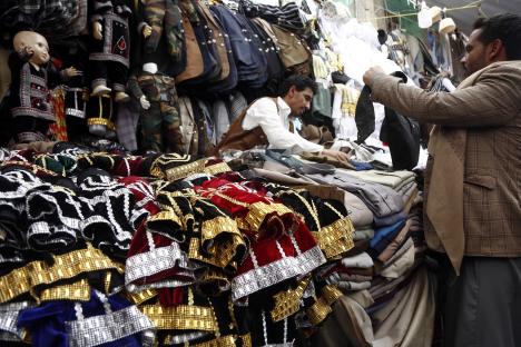 Shoppers browse clothing at a market.