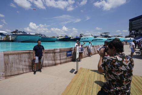 Race fans taking photos at a man-made marina.