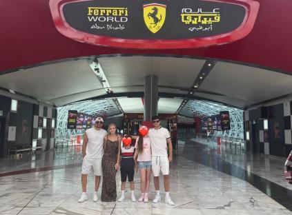 Family posing in front of Ferrari World Abu Dhabi entrance.