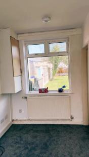 Empty room with a window looking onto a garden.