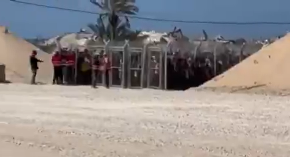 People standing near a gated structure.