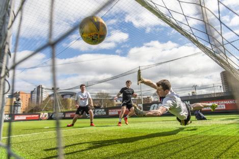 Goalkeeper diving to catch a soccer ball.