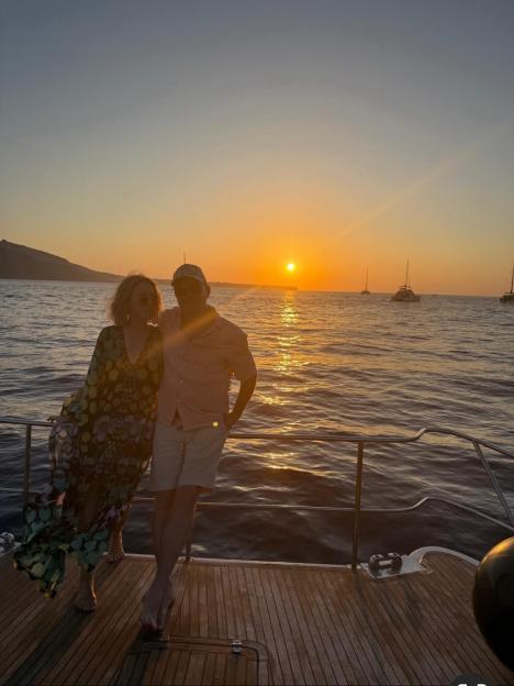 A couple on a boat enjoying a Santorini sunset.