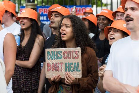 Junior doctors rally outside Downing Street, holding a sign that reads