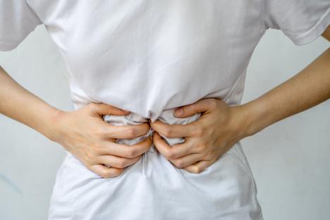 Woman holding her stomach in pain.